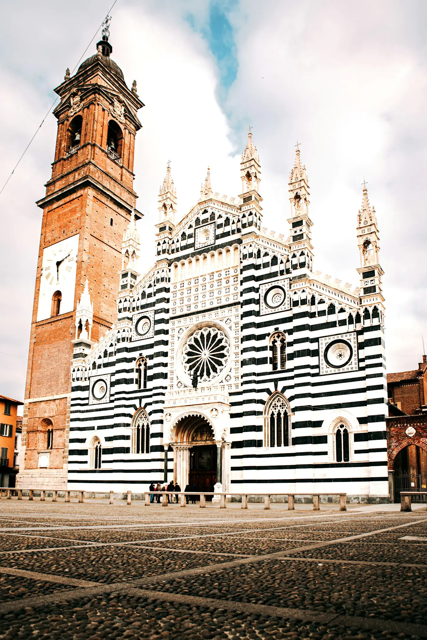 The striped facade and brick bell tower of Monza's Duomo